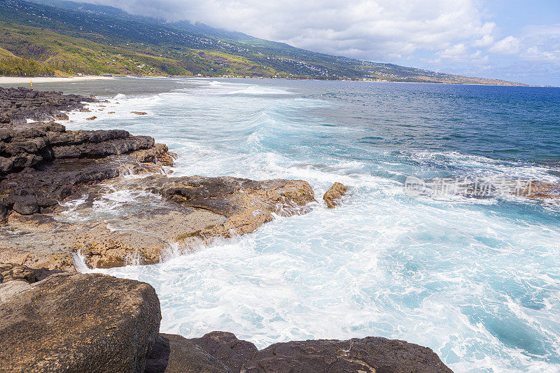 Les Trois-Bassins岩石海岸，La Reunion岛晴朗的一天与强烈的蓝色大海。